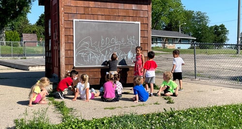 students outside using a chalkboard